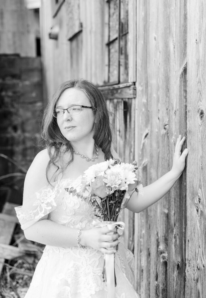 A bride stares off into the distance at her husband just newly married in their backyard.