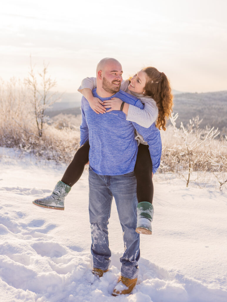 Brendan gives Mia a piggy back ride during golden hour at their engagement session in the White Mountains.