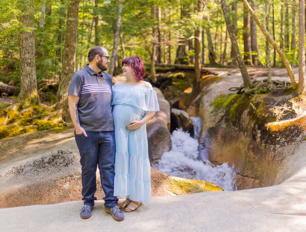 A couple standing in front of a waterfall at The Basin in NH.