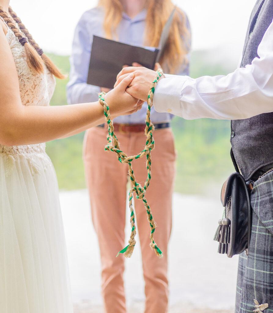 The bride and groom perform hand fasting during their elopement ceremony to follow a Celtic tradition. 