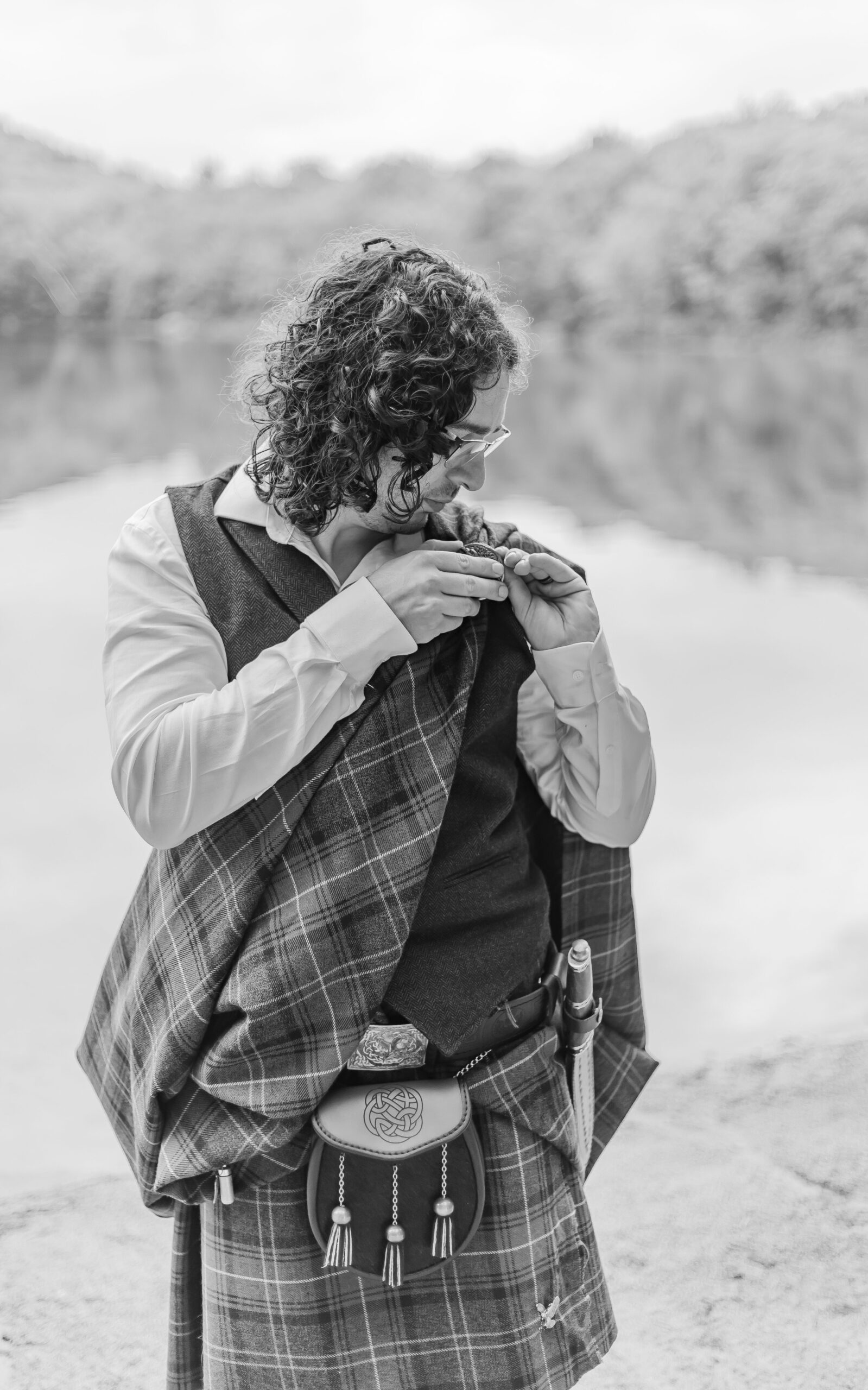 The groom finishes putting on his kilt for his wedding ceremony in Franconia Notch.