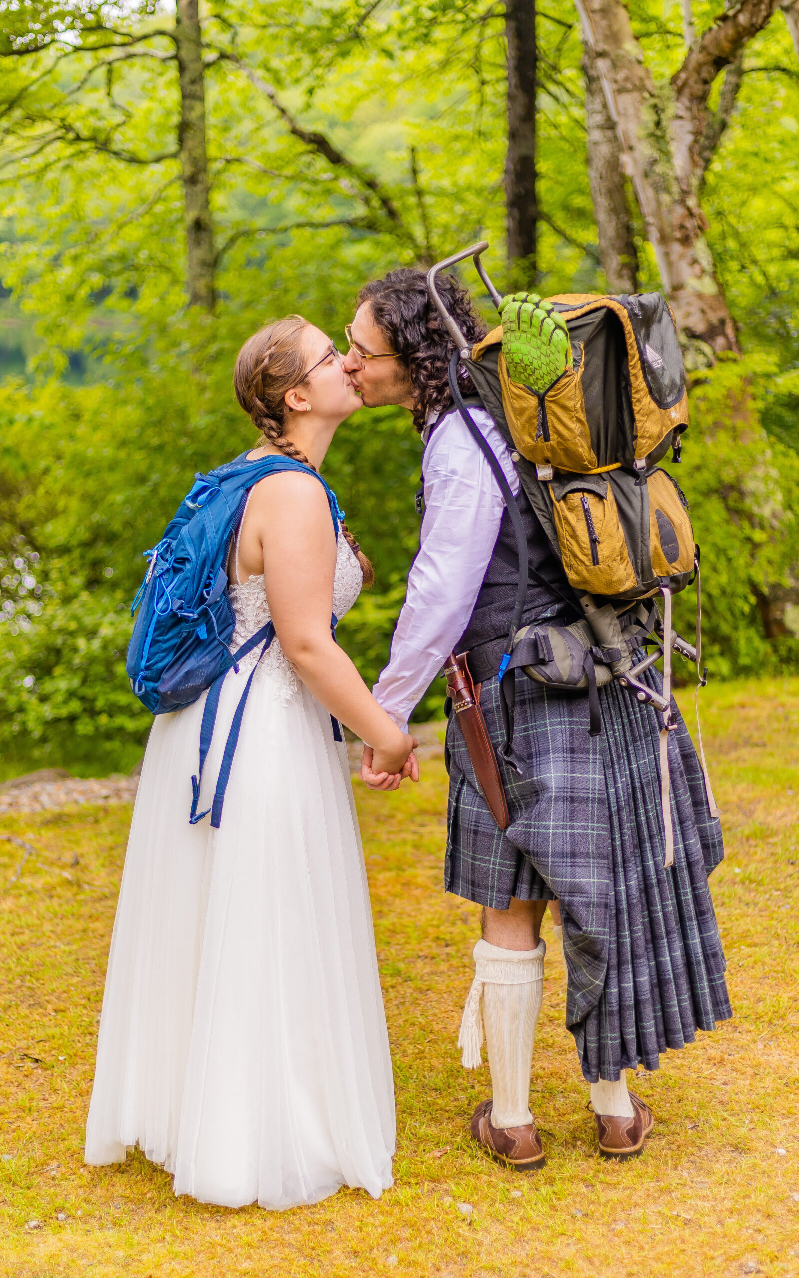 The bride and groom wear their hiking backpacks together because they share a love for hiking the NH 4000 footers. 