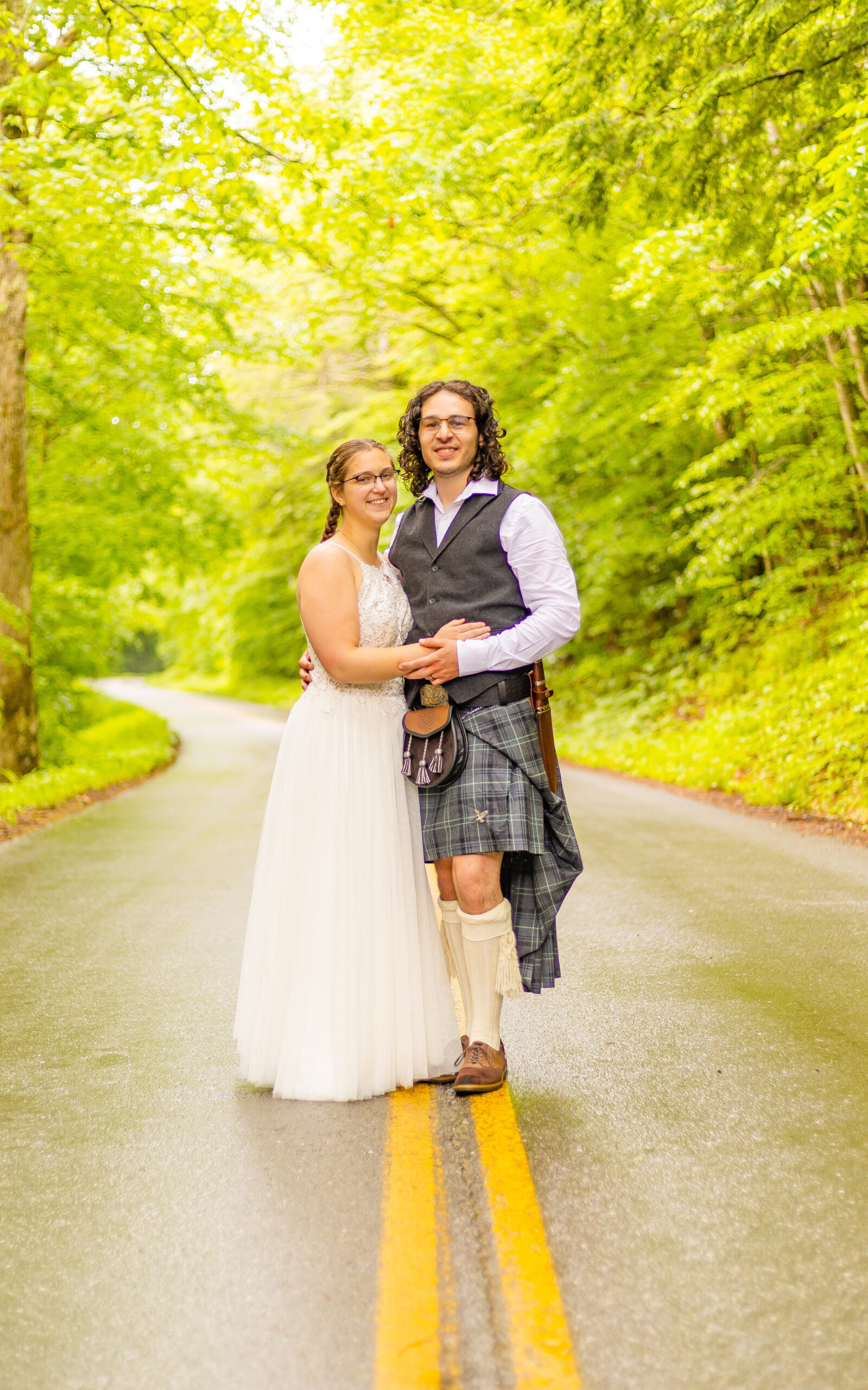 The bride and groom stand on the winding Tripoli road in New Hampshire.