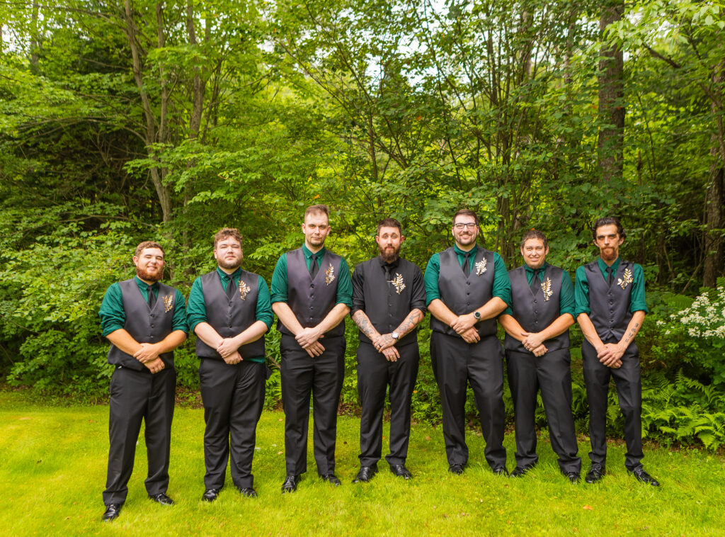 The groomsmen stand together before the bride and groom get married in New Hampshire. 
