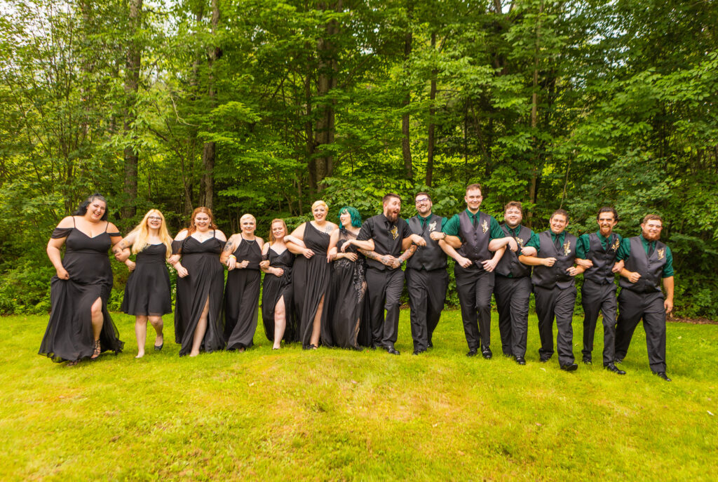 The bridal party walks together at their forest wedding venue in New Hampshire. 