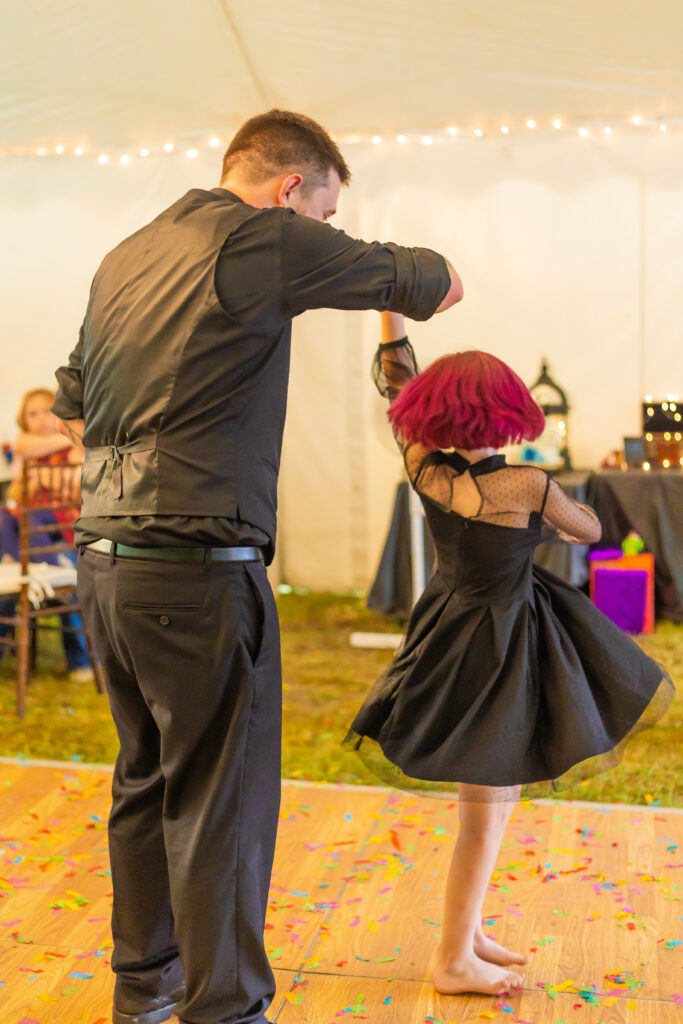 The groom spins his daughter during their dance. 