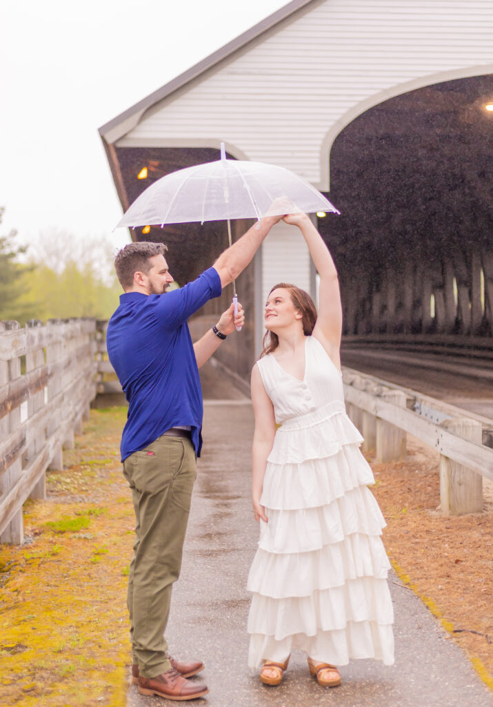 Ben spins Katie under their umbrella during their rainy engagement session in Plymouth, NH.