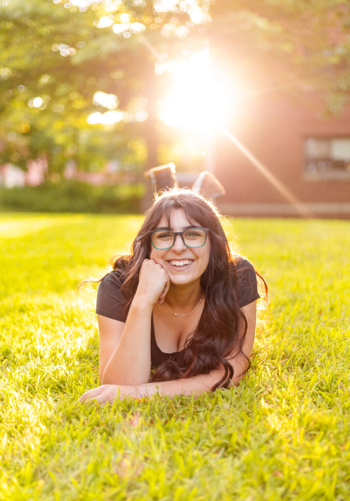 A senior laughs happily about her future as a college senior during golden hour at her senior session in Plymouth NH. 