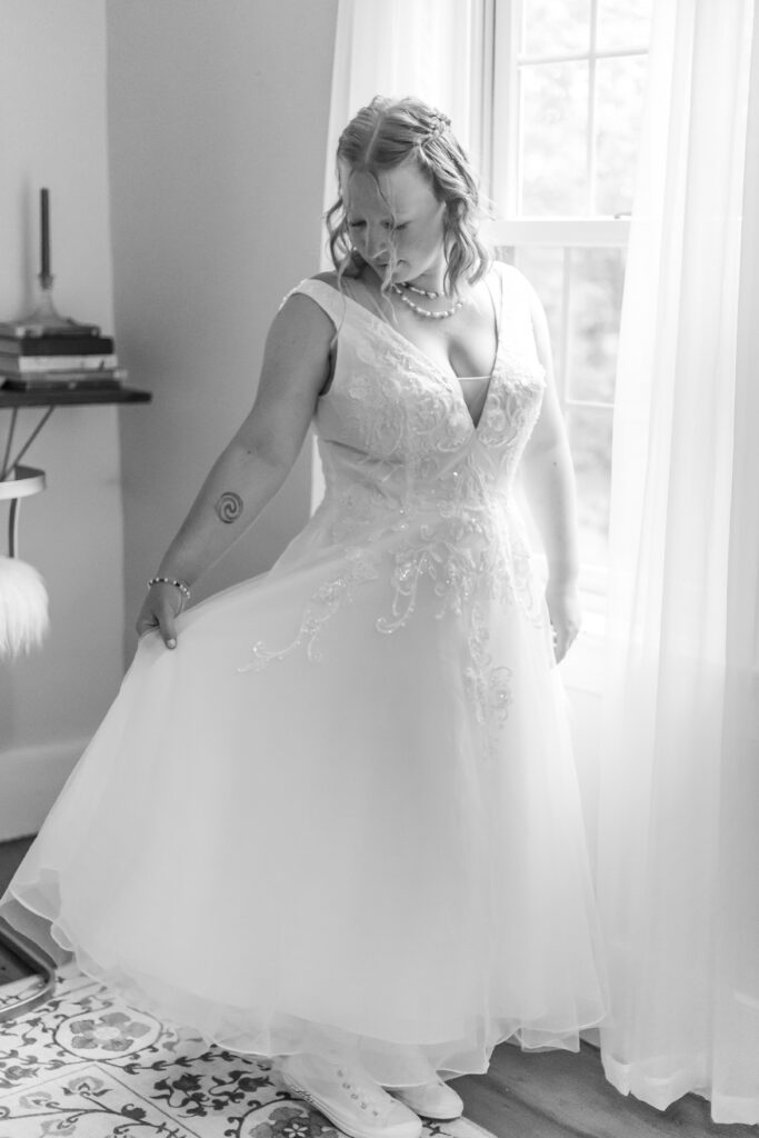 Bride admires the tulle of her dress during getting ready photos