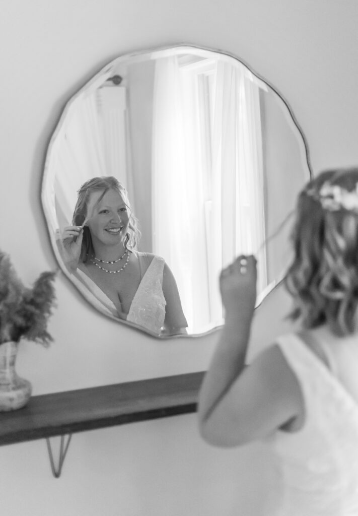 The bride stares at her reflection in the mirror