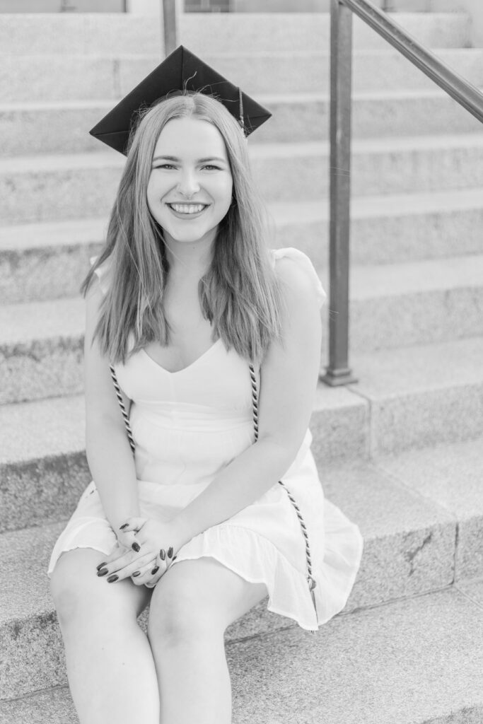 Durham NH college grad sits of the stairs at UNH.