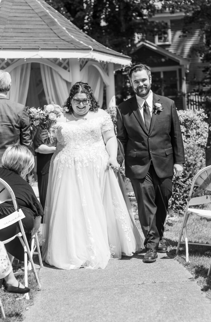 The bride and groom walk down the aisle for the first time as husband and wife at their wedding at an Inn in Hampton, New Hampshire. 