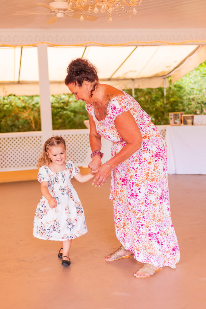 A little girl and a guest dance together at the wedding.