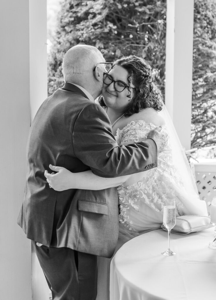 The bride hugs her father after he gives a wedding toast.