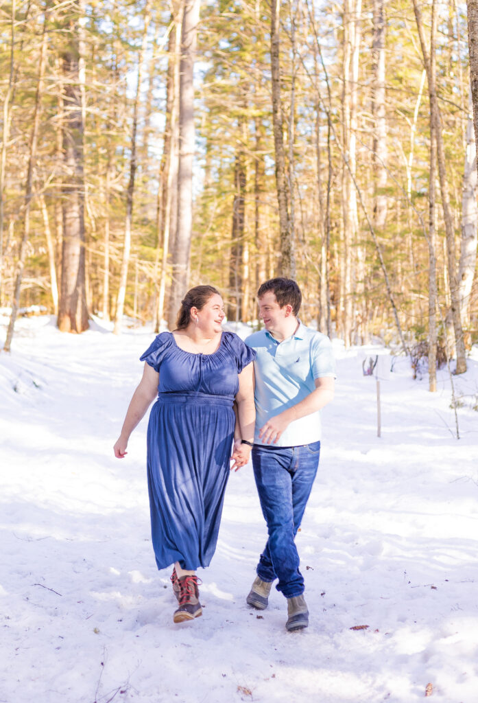 A couple frolics through the woods at their engagement session the White Mountains. 