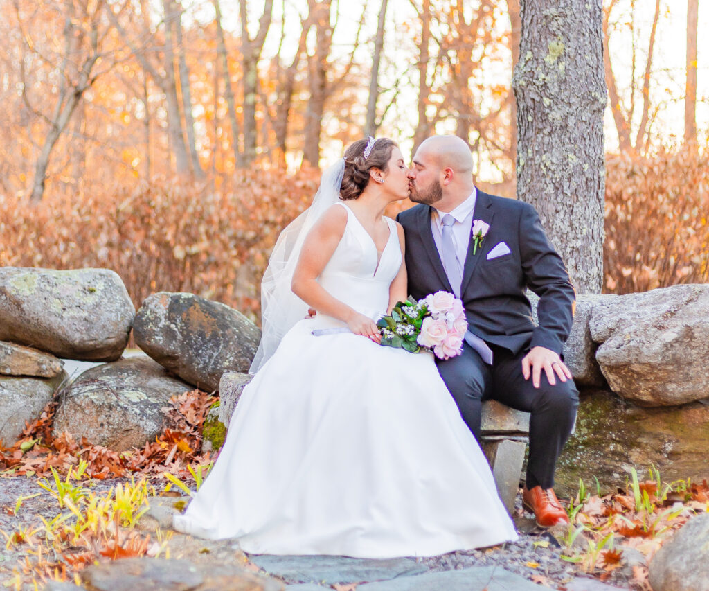 A newly married couple kisses on a bench at Steele Hill Resort in Sanbornton, New Hampshire. In 20 questions to ask your wedding photographer.