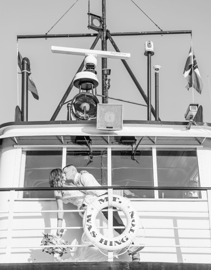 Bride and groom share a kiss on the top of the Mount Washington Cruise Ship.