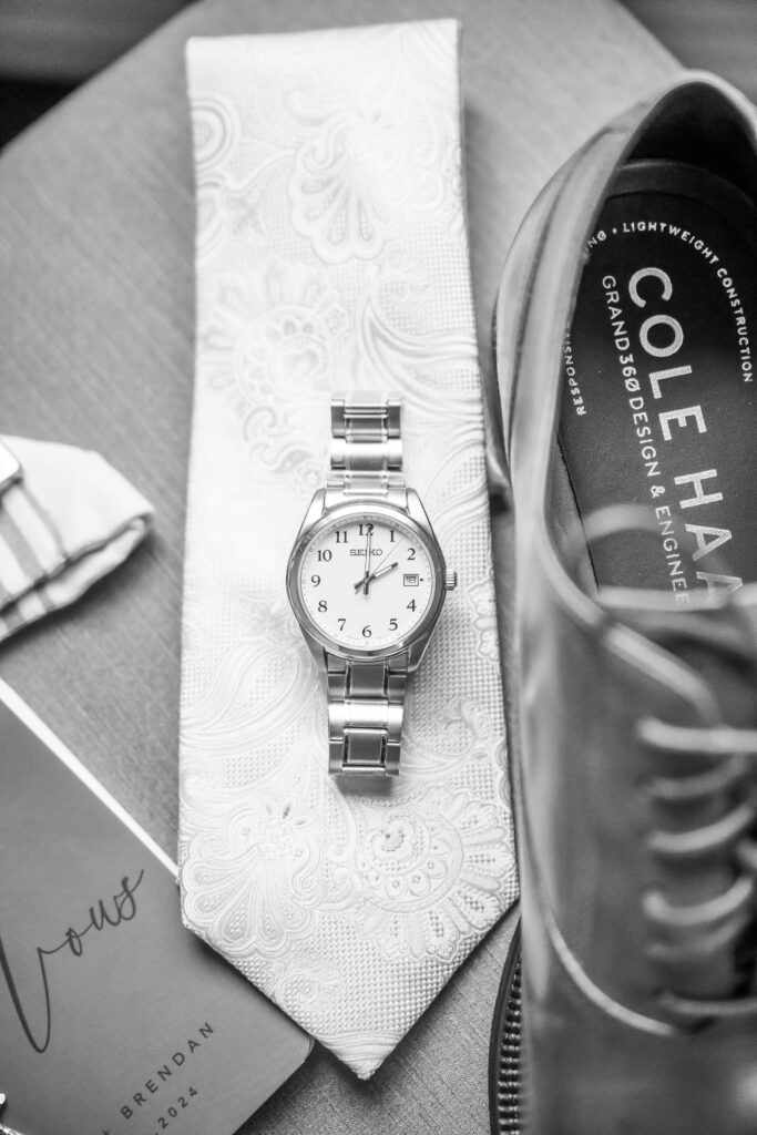 The grooms watch and tie are part of his wedding details.