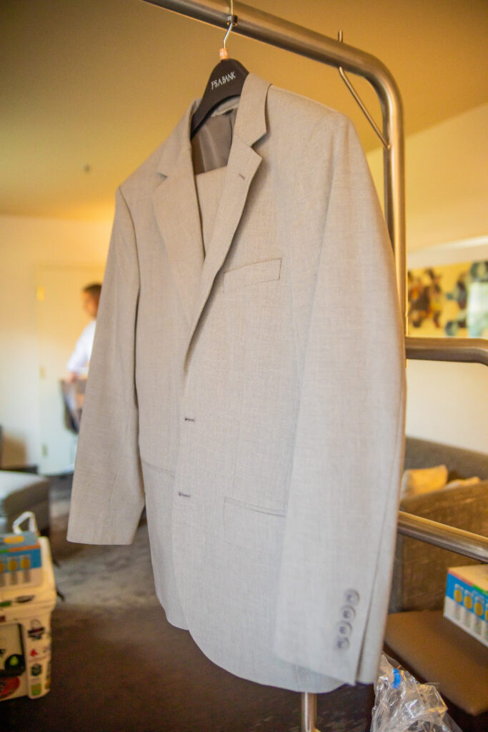 The groom's jacket hanging on the rack.