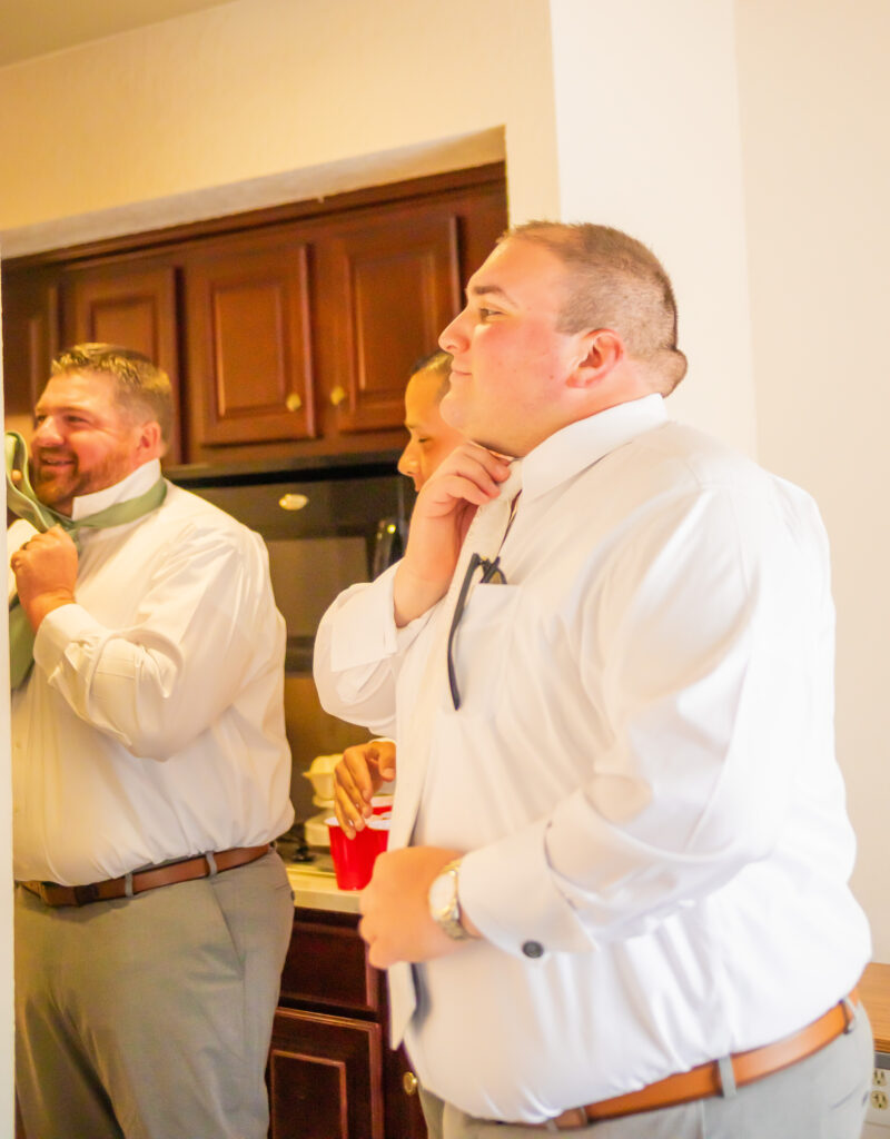 The groom putting his tie on.