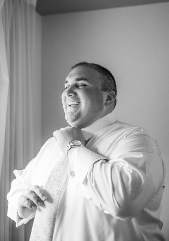 Groom putting his tie on for his wedding in Hampstead, NH.