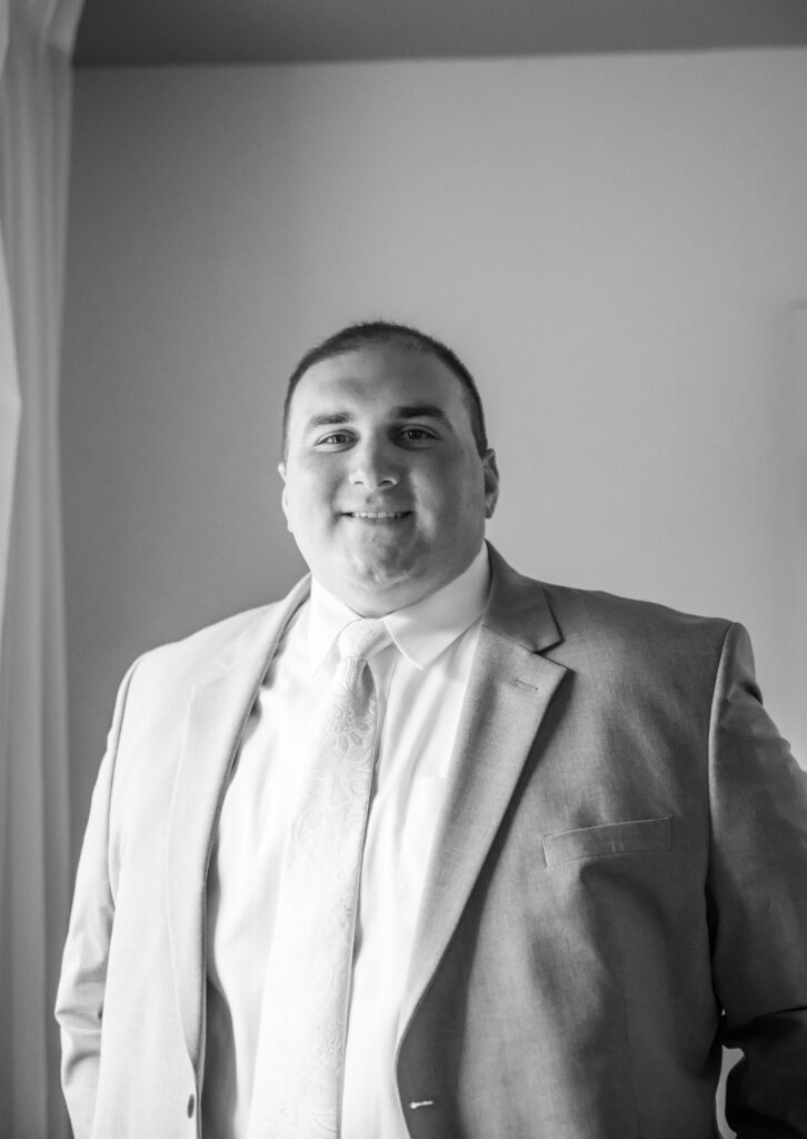 Groom smiles all dressed for his wedding day.