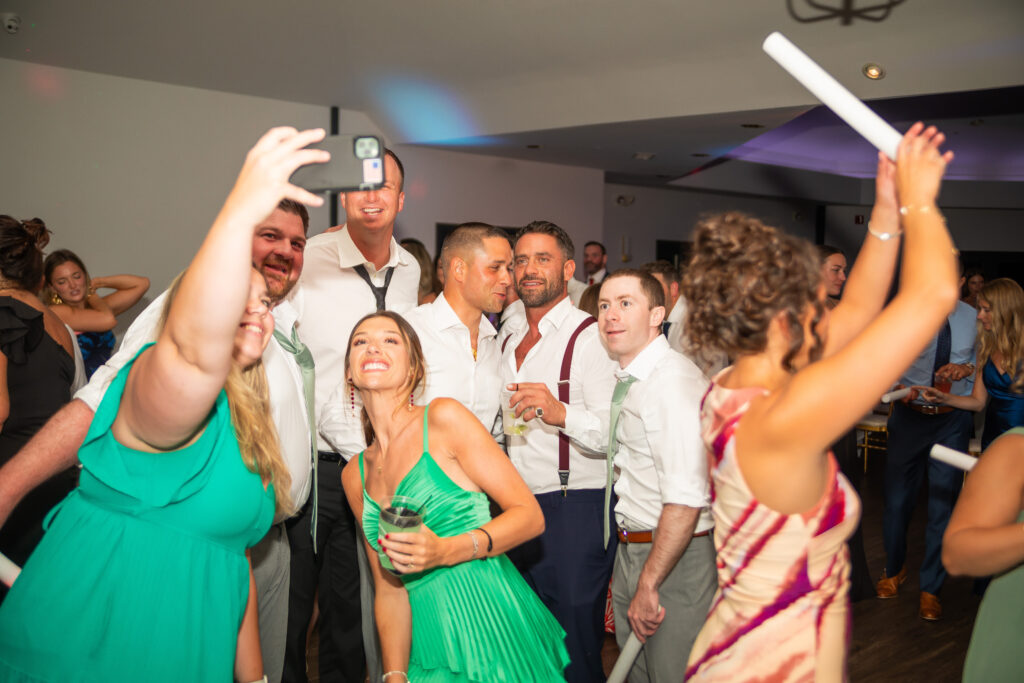 Wedding party posing for a selfie on the dance floor.