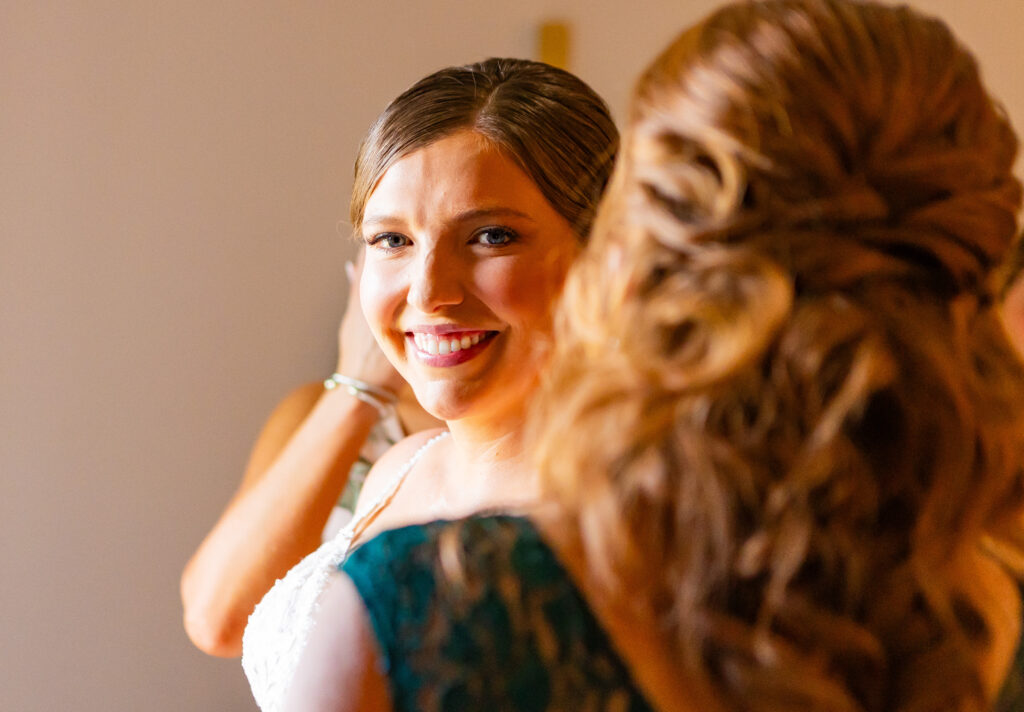 Bride looks over the mother of the brides shoulder.