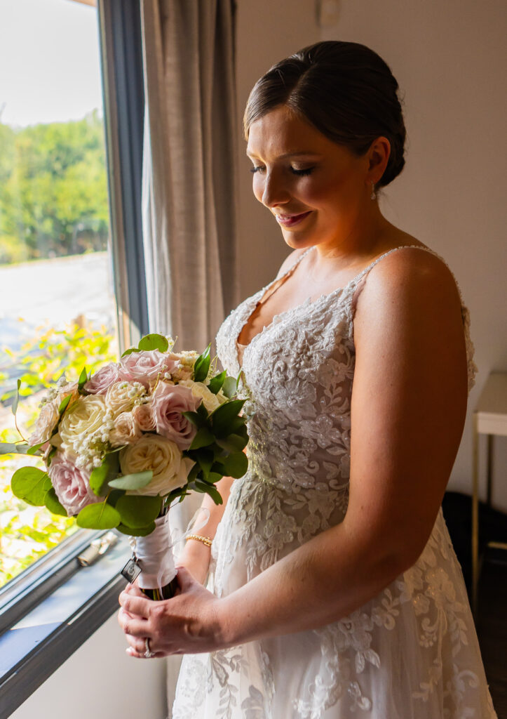 Bride glances down at her flowers moments from her NH wedding ceremony. 