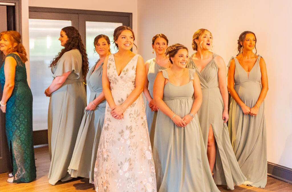 Bridesmaids react to bride in her wedding dress for the first time.