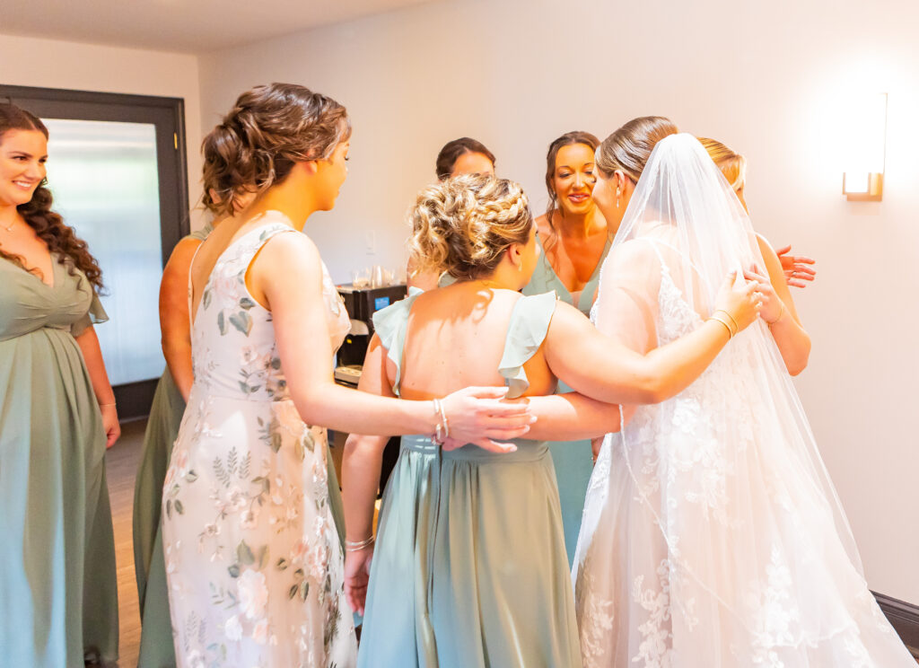 Bride and bridal party go in for a hug.