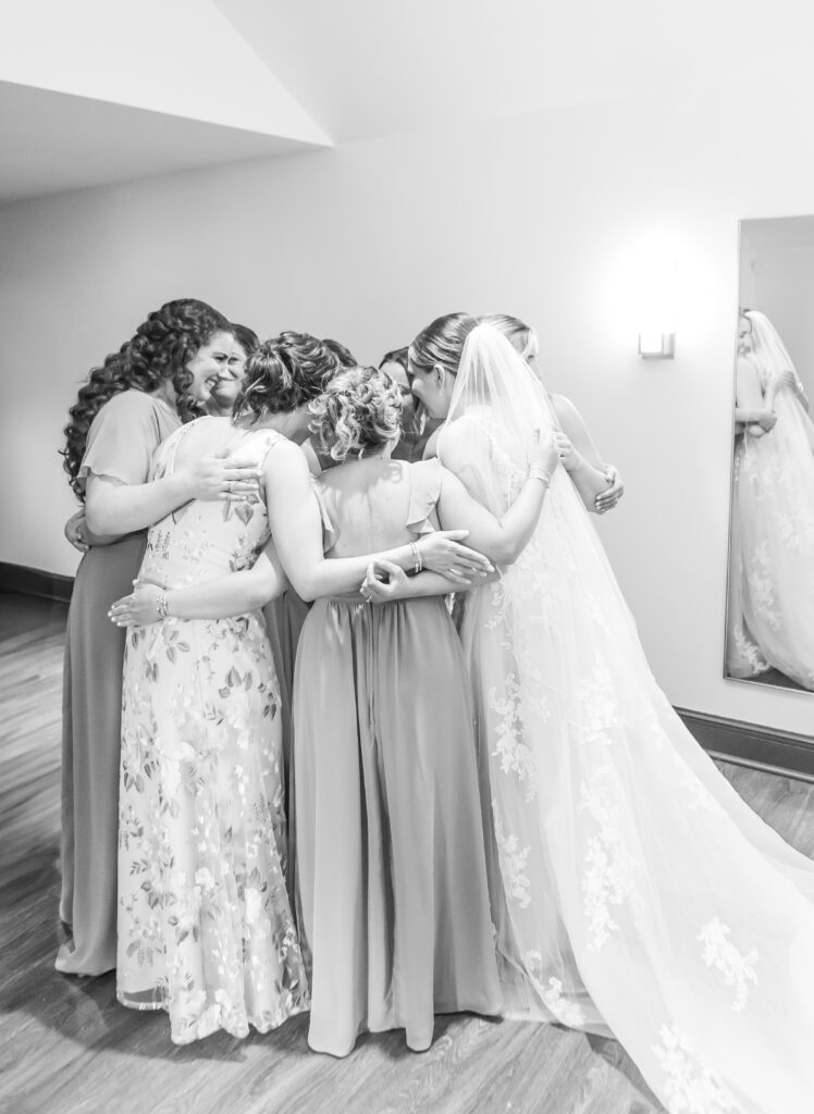 A tender moment between the bride and her bridesmaids.