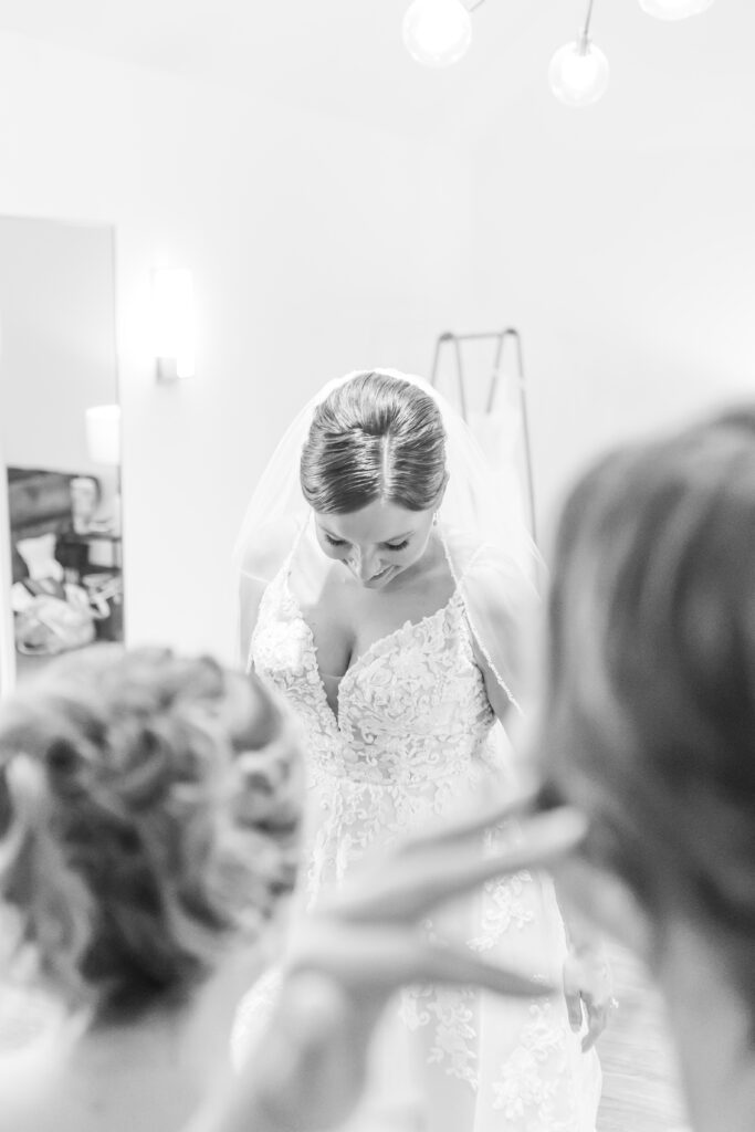 Bride admires her own wedding dress.