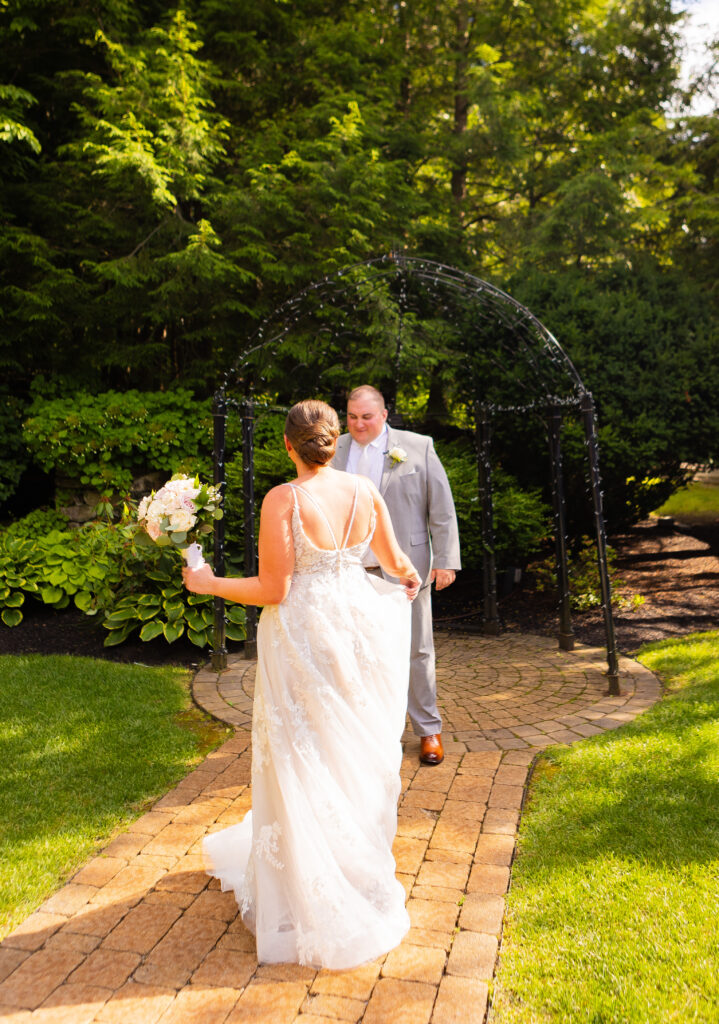 Bride does a twirl for her groom in her wedding dress a their New England wedding venue. 