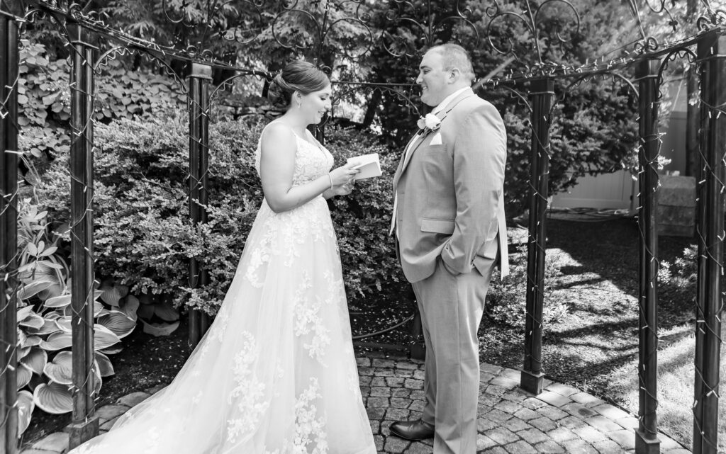 Bride giggles while reading vows to her groom.