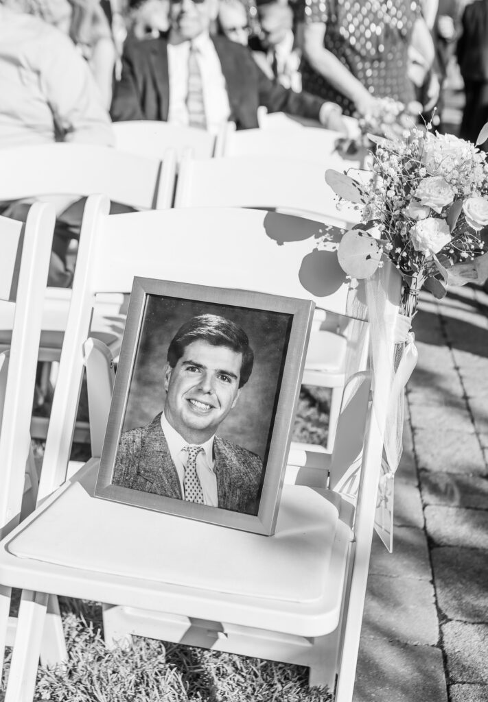 A reserved seat for the father of the bride is signified by his photo on a seat at this NH wedding ceremony.