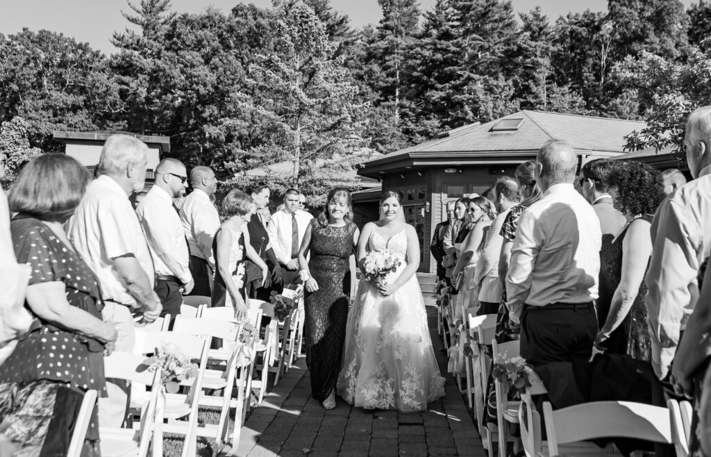 Bride walks with the mother of the bride down the aisle at their Hampstead, New Hampshire wedding.