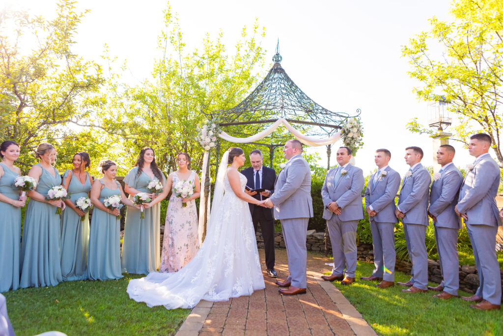 Bride and groom hold hands at their wedding ceremony.