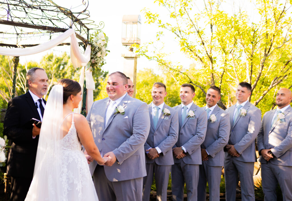 Groom laughing during their wedding ceremony.