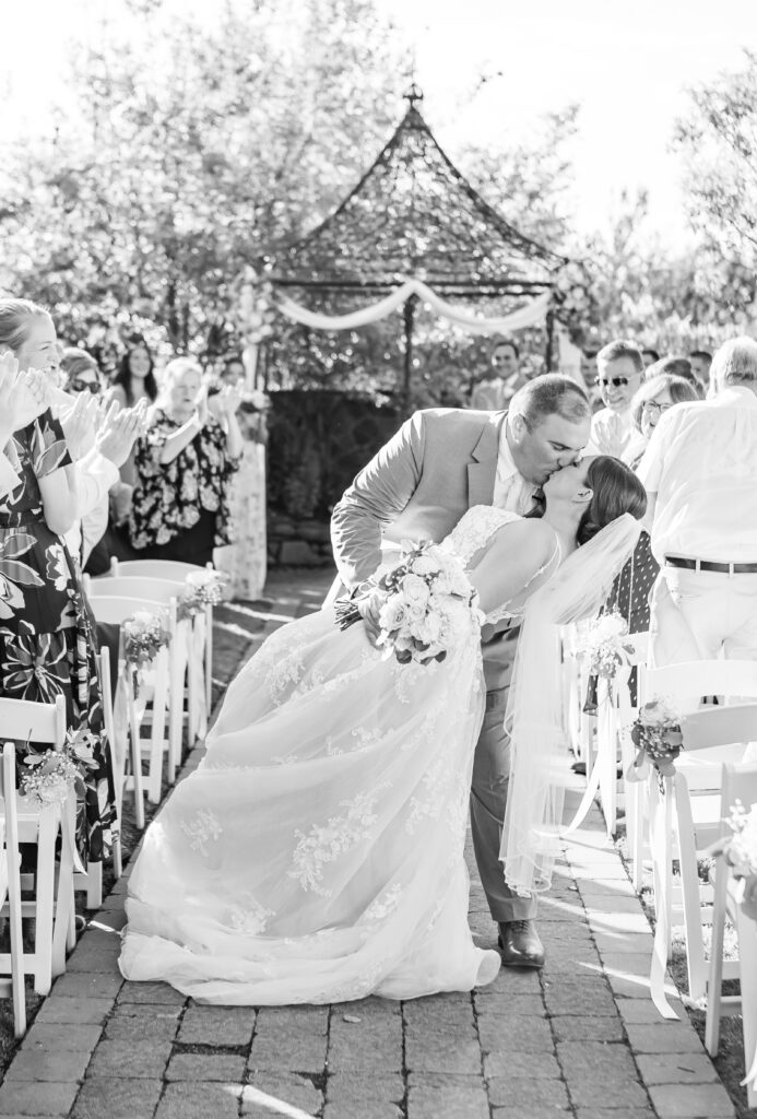 Groom dips his bride walking back down the aisle of their NH wedding ceremony.