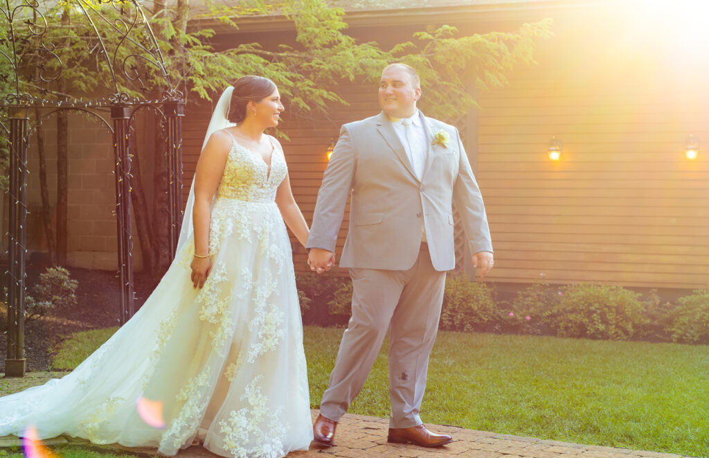 Bride and groom holding hands at their classy NH wedding venue.