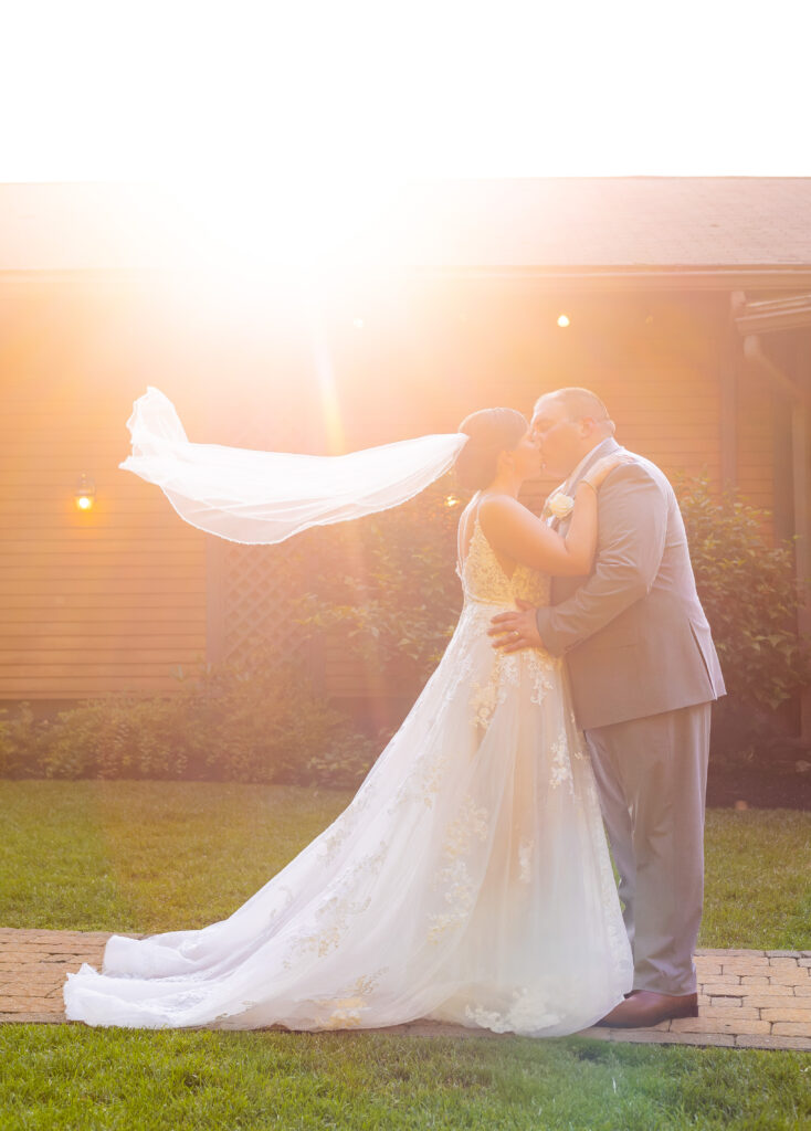 Bride and groom veil photos at golden hour.