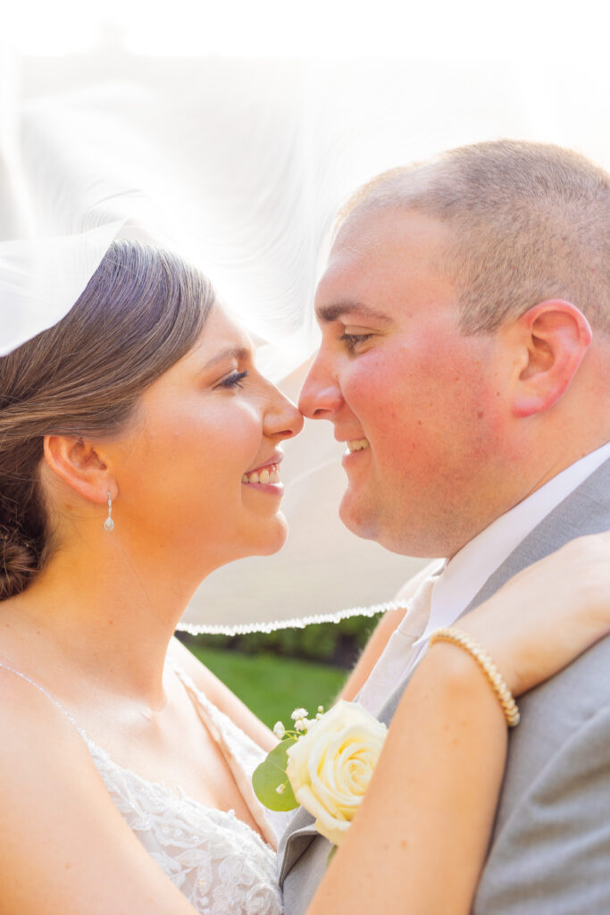 Bride and groom look into each other's eyes lovingly under the veil.