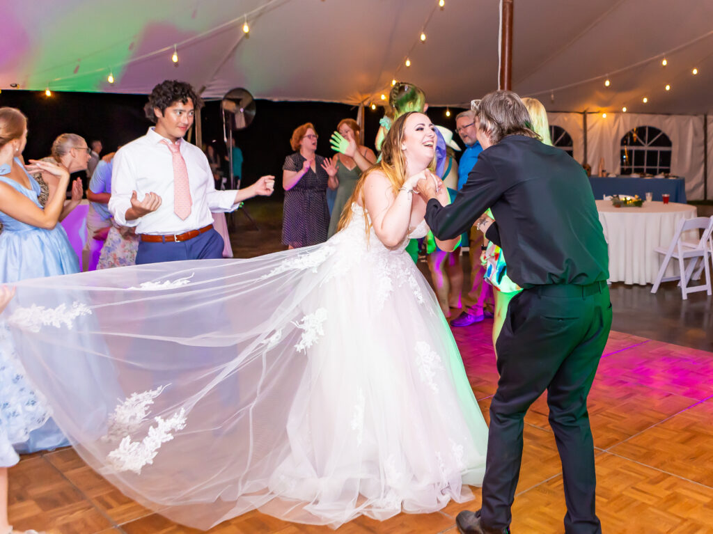 Bride dancing with one of the groomsmen at her wedding.