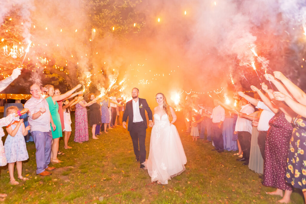 Bride and groom walk through their sparkler exit at Stone Garden.