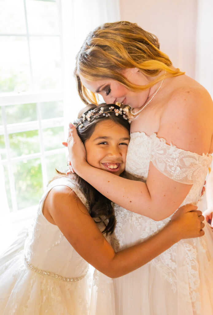 Bride and flower girl share a hug in the bridal suite at Stone Garden in Westmoreland, NH.