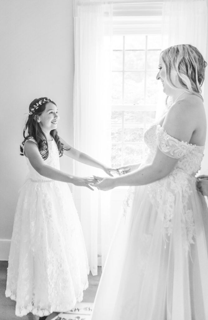 Bride and daughter admiring each other moments before walking down the aisle at their forest wedding venue in NH.