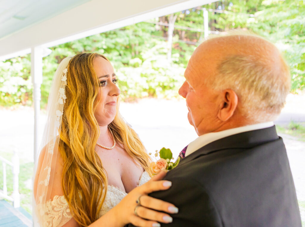 Bride and groom sharing a first look on the front porch of their stone garden wedding.