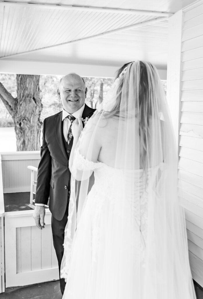 Dad smiles at his daughter who is a bride.