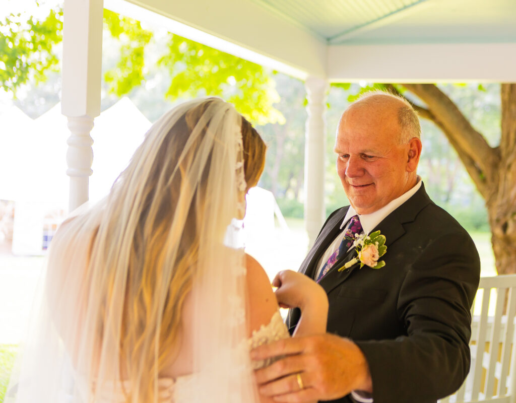 Father admiring her daughter's wedding dress from Aliber's Bridal in Massachusetts.